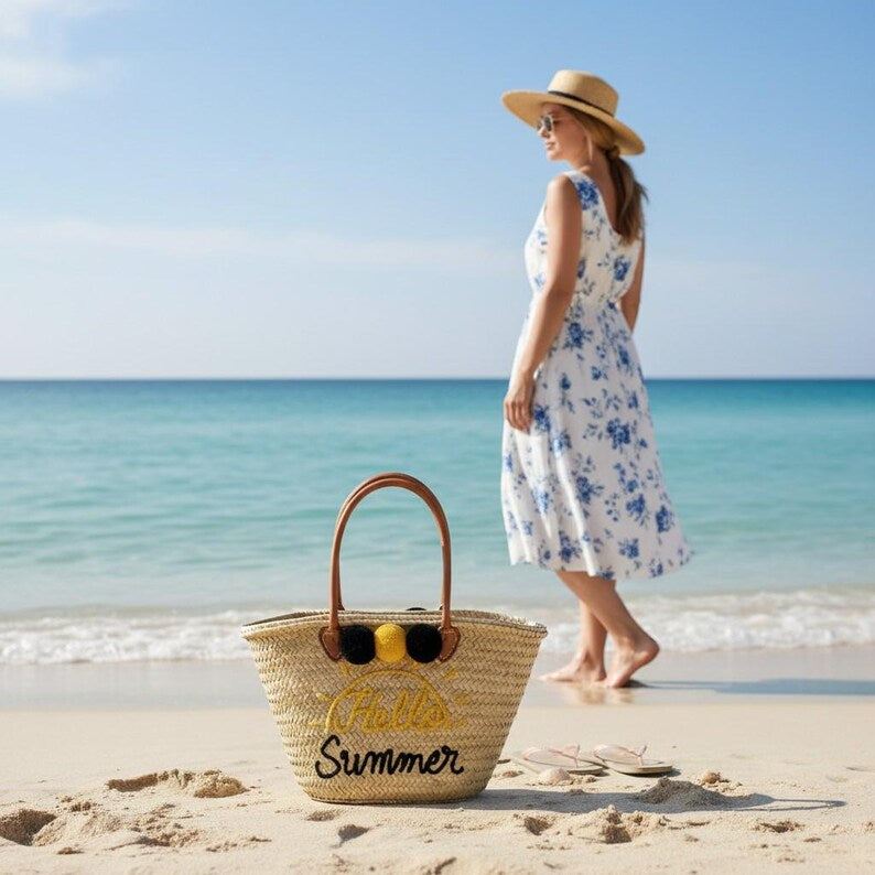 Natural straw tote with cursive Hello Summer embroidery and pompom detail