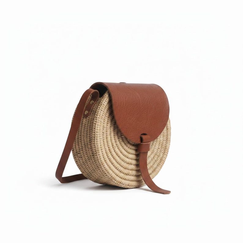 Natural straw circle bag with genuine leather closure and long strap