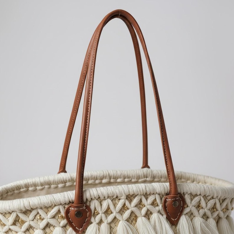 Detail of leather handles with macramé overlay on woven straw bag