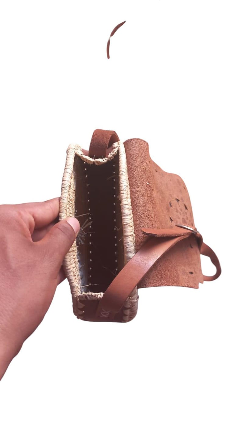 Detail of genuine leather flap and straw weave on round bag